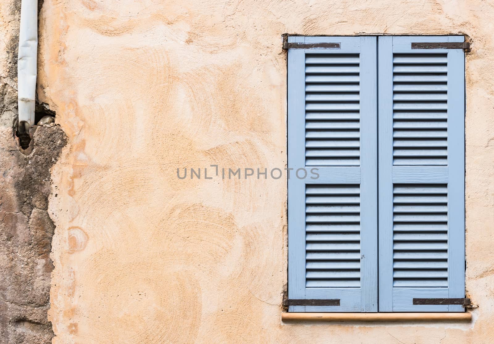 Detail view of wooden window shutters and wall