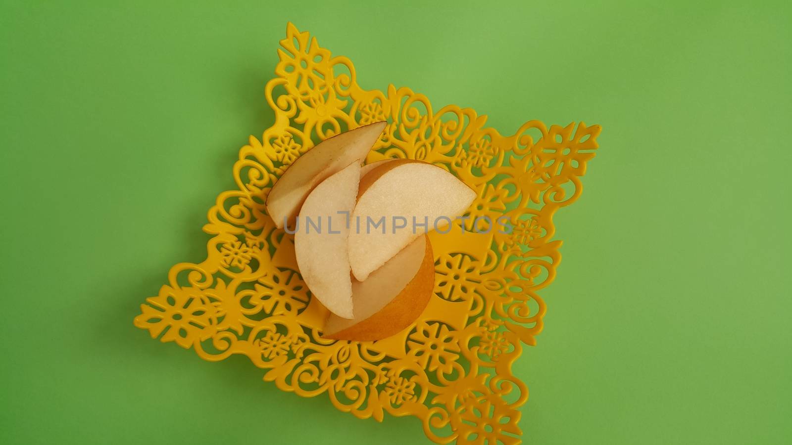 Close up view of apple slices placed in plastic yellow changair or container on a wooden floor. Fruit background for text