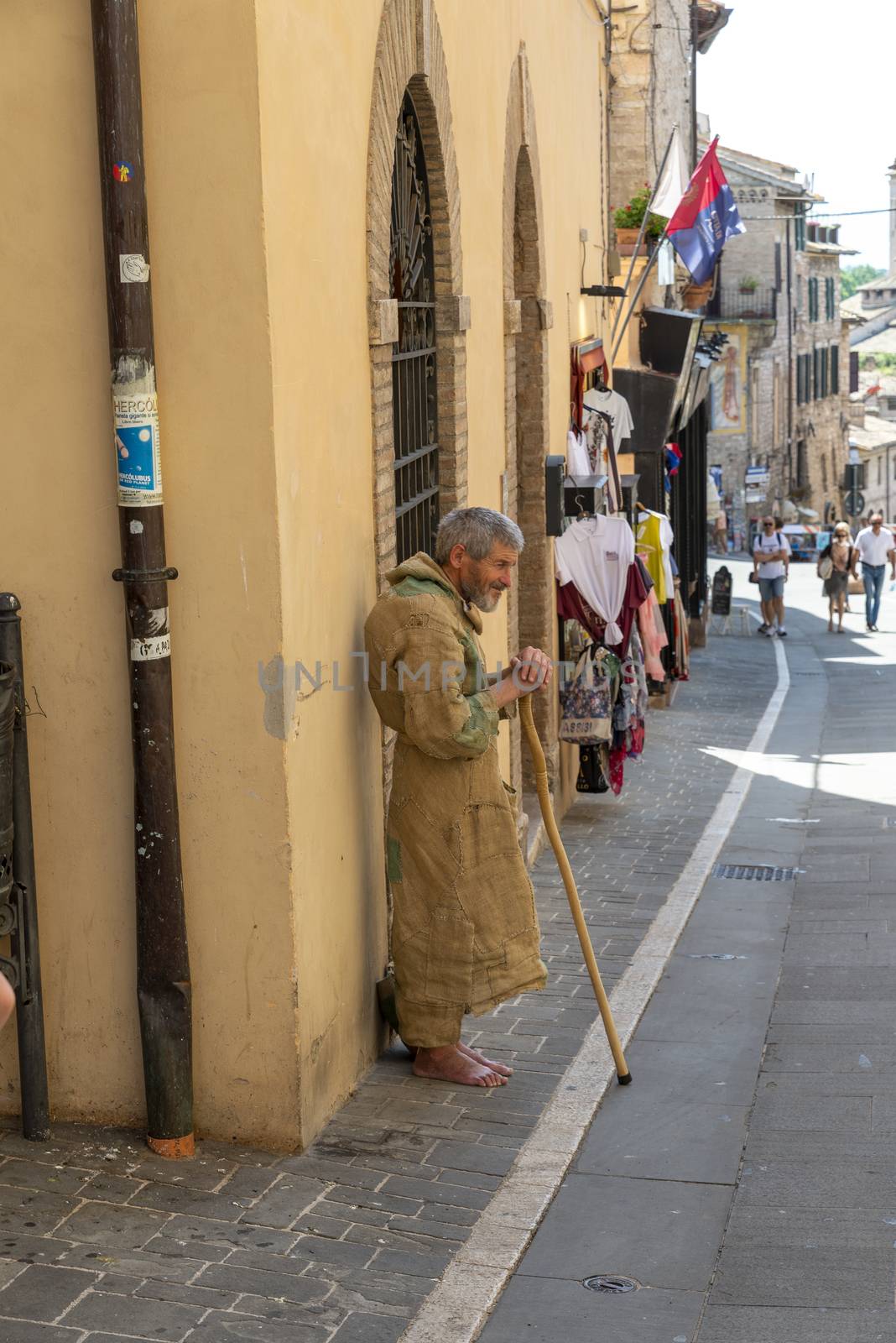 barefoot hermit asking for alms in a street of assisi by carfedeph