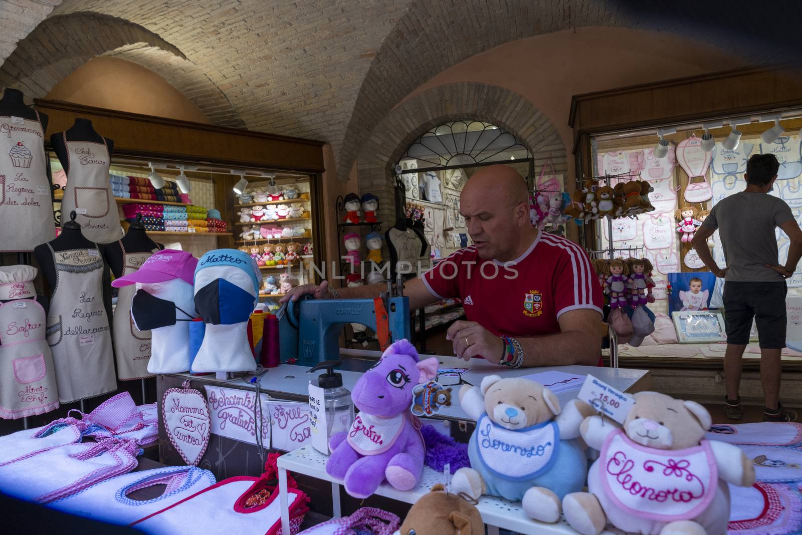 assisi,italy july 11 2020:man embroidering decorations on fabric with machinery