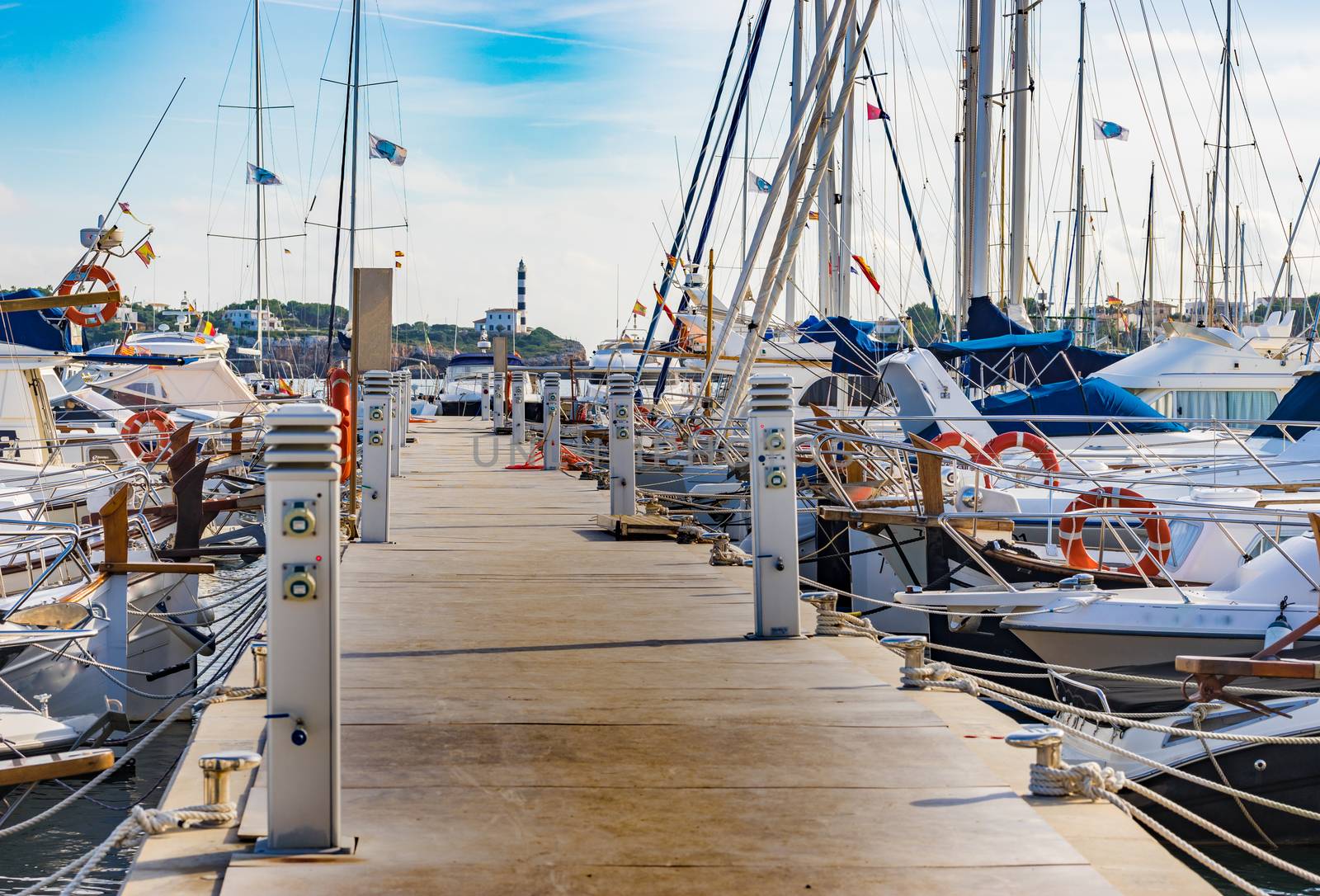 Pier at Portocolom harbor with view of the lighthouse on Majorca island, Spain Balearic islands