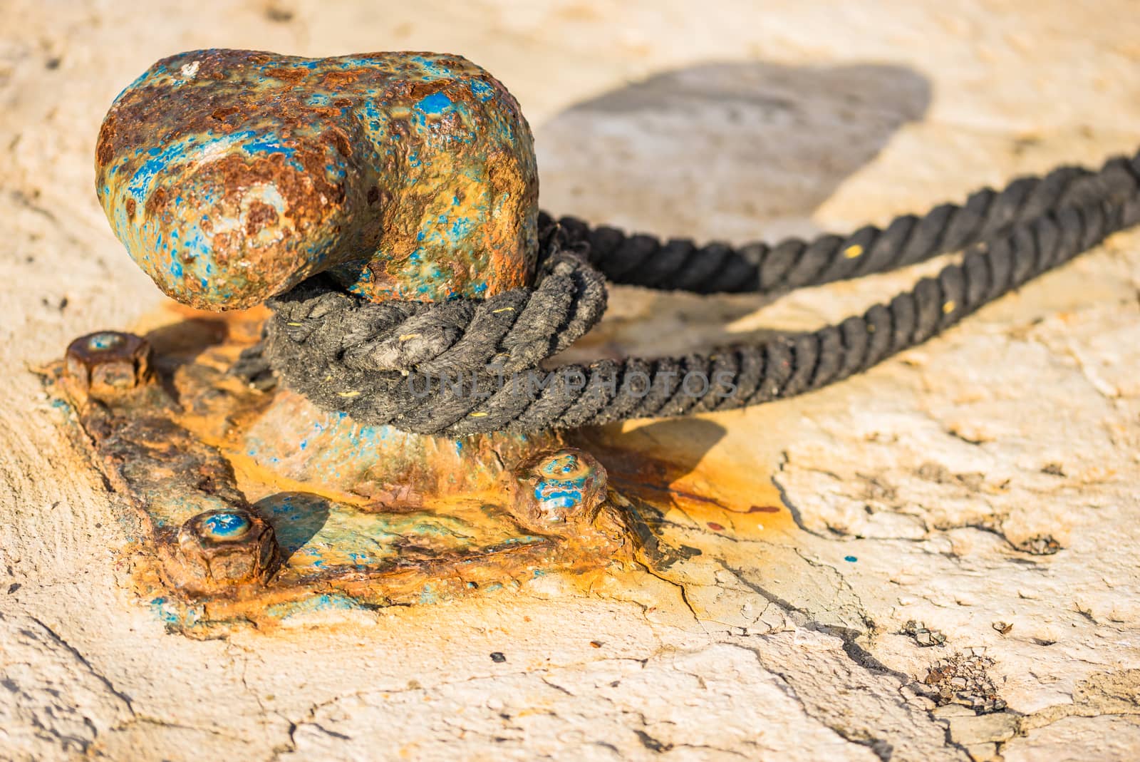 Detail view of mooring post with moored rope at harbour