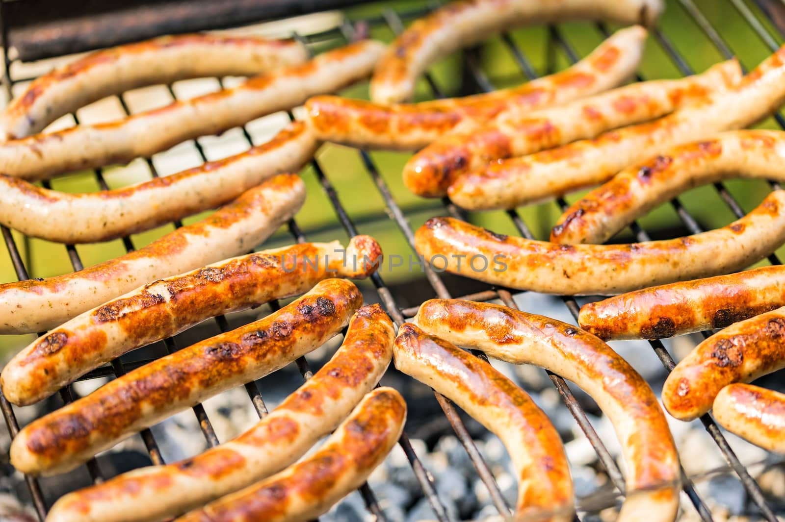 Grilled sausages on barbecue grill, close-up