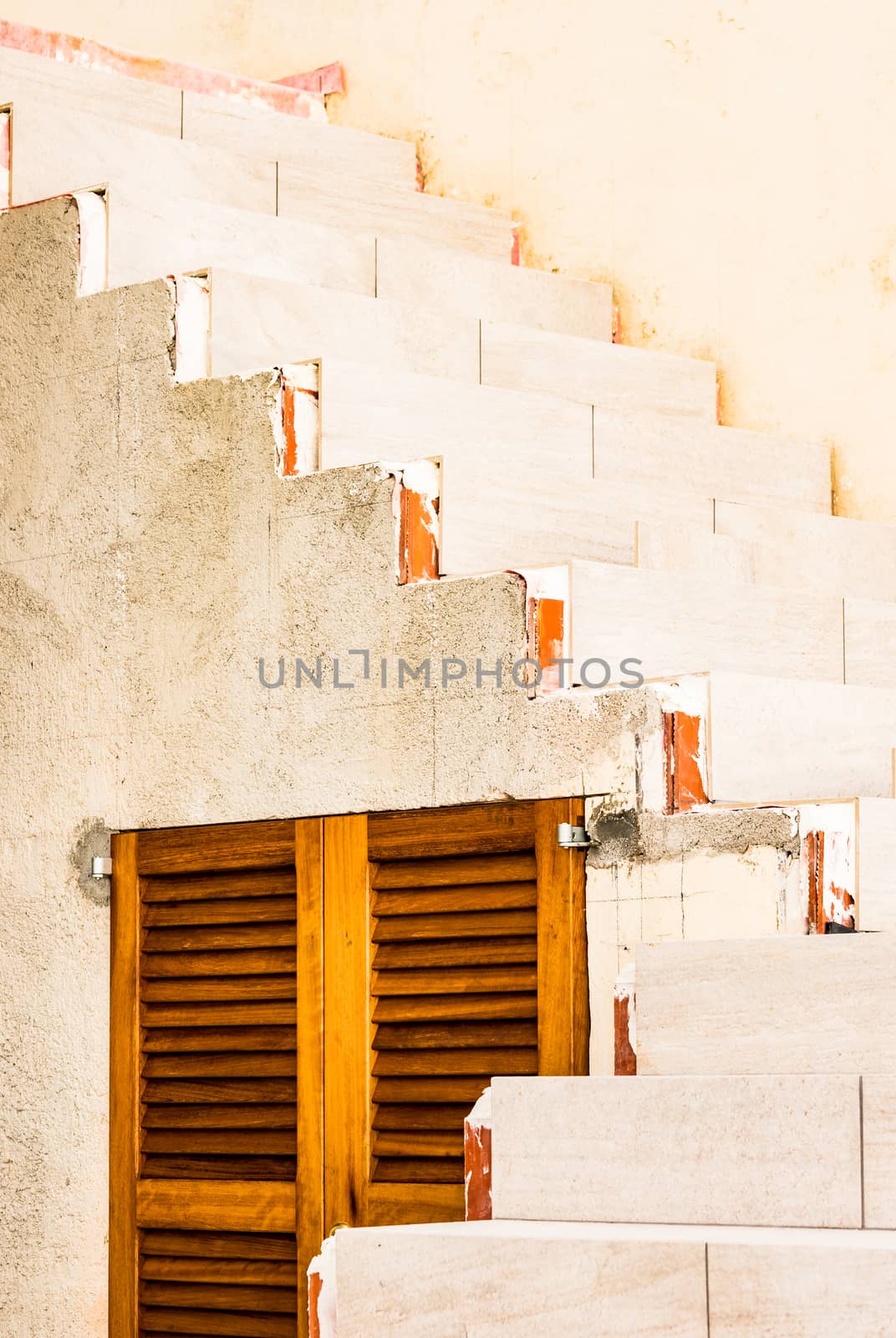 View of concrete staircase with brown wooden window