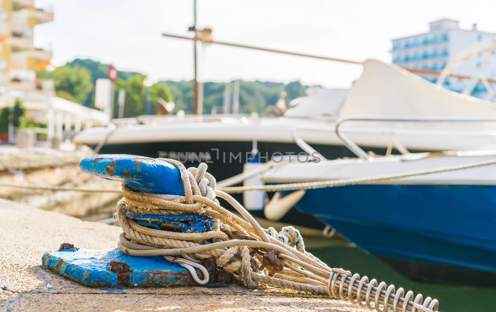 Close-up of mooring bollard with moored ropes