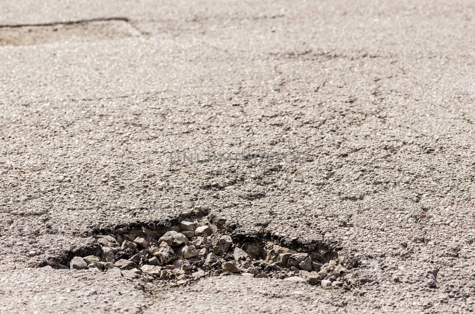 Close-up of damaged street with pot hole