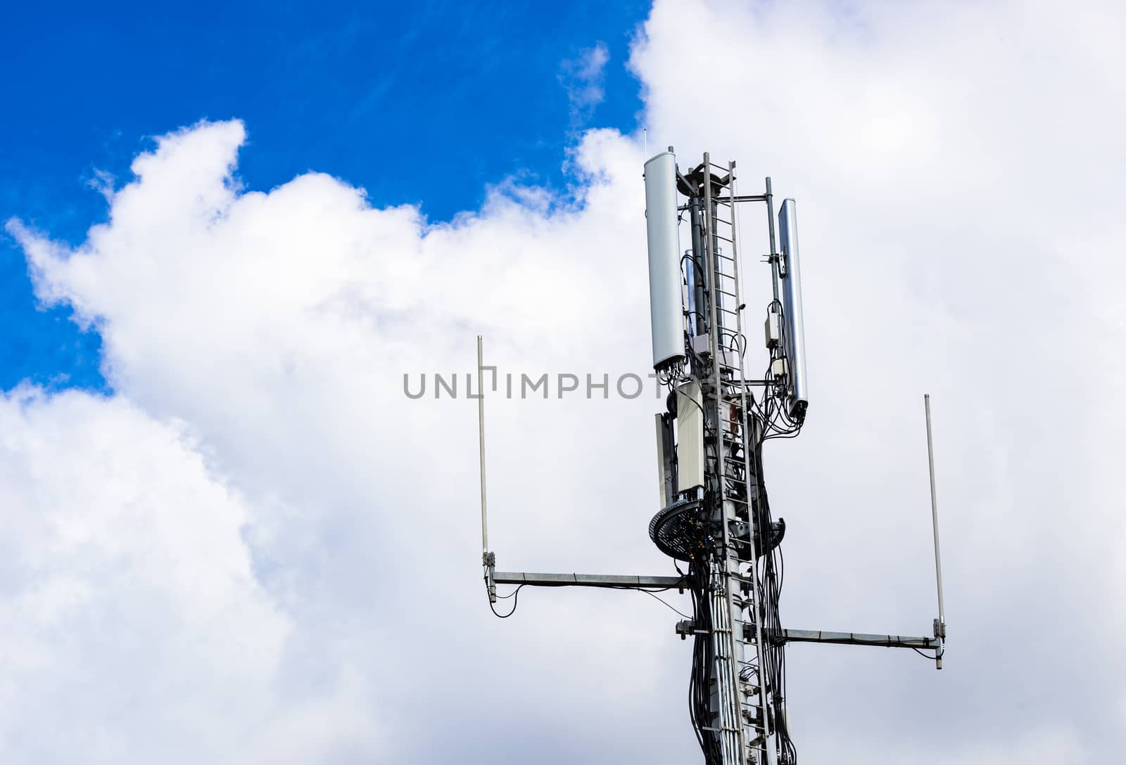 Detail view of telecommunication tower with cloudy sky background