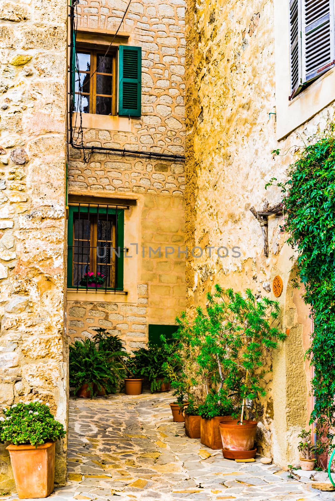 Old spanish village houses and cobblestone street by Vulcano