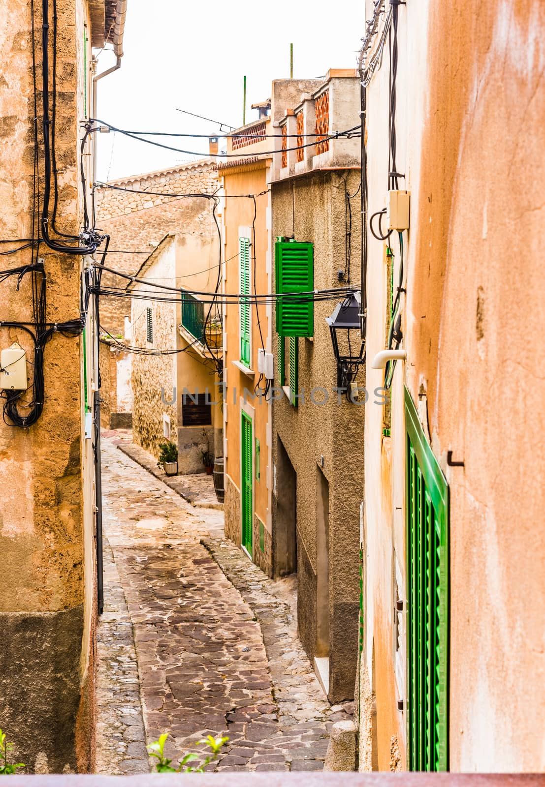 Old spanish village houses and cobblestone street by Vulcano