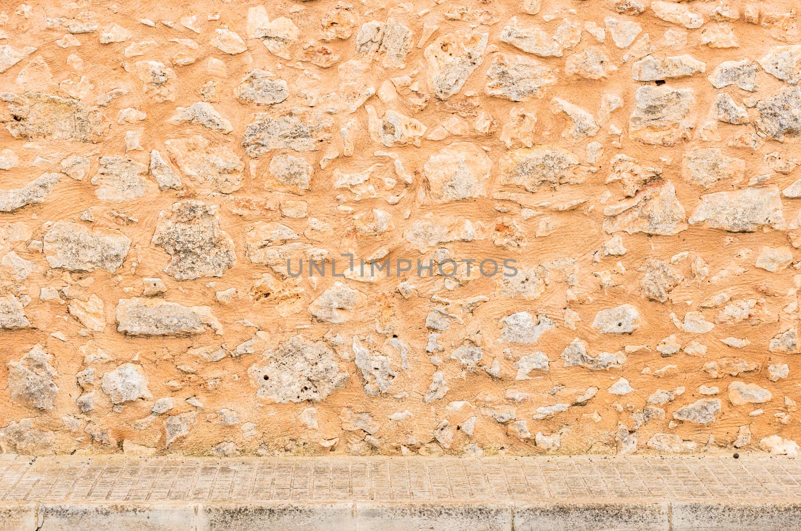 Vintage stone wall texture background with pavement

