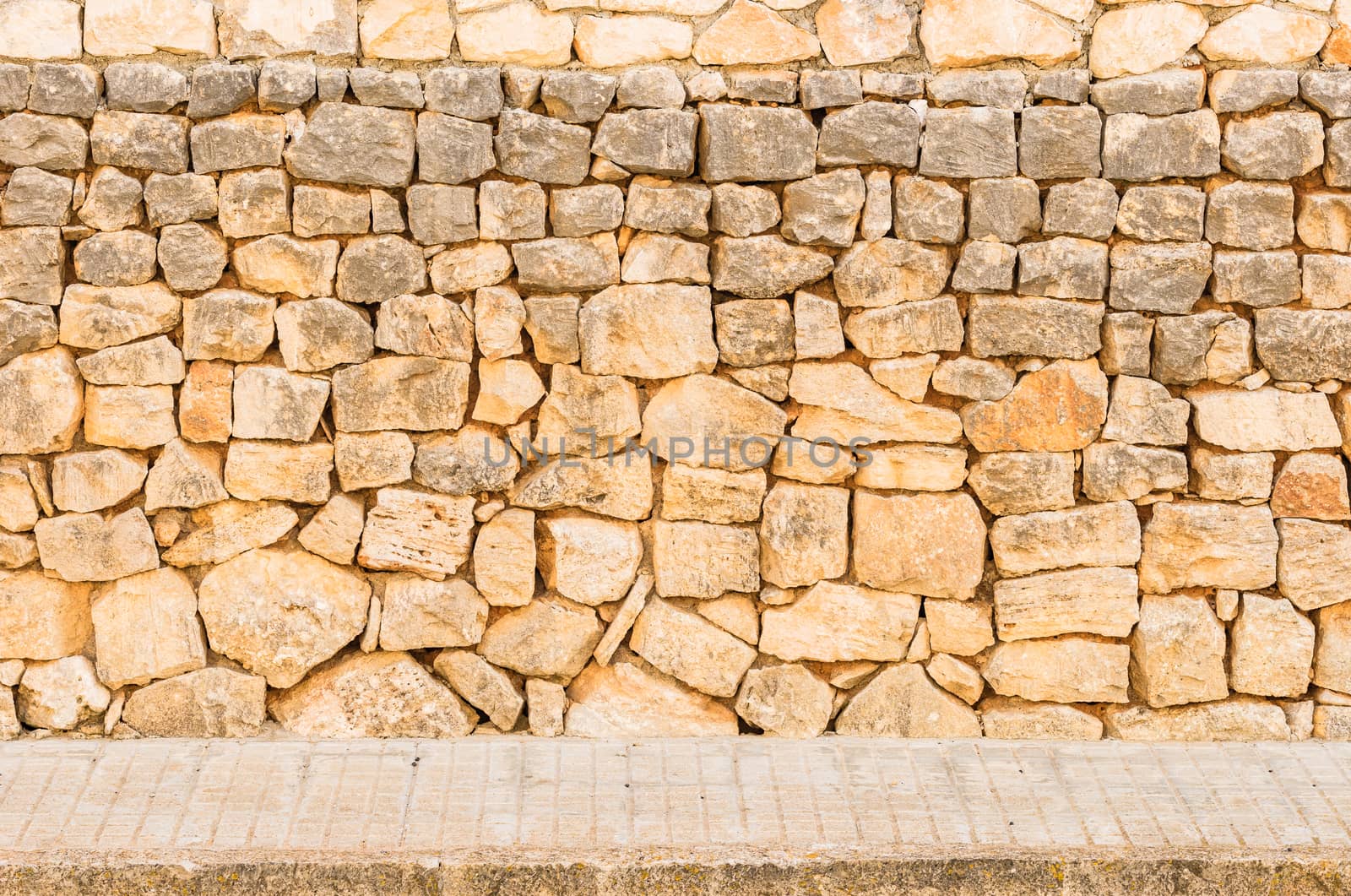 Vintage stone wall background texture with pavement