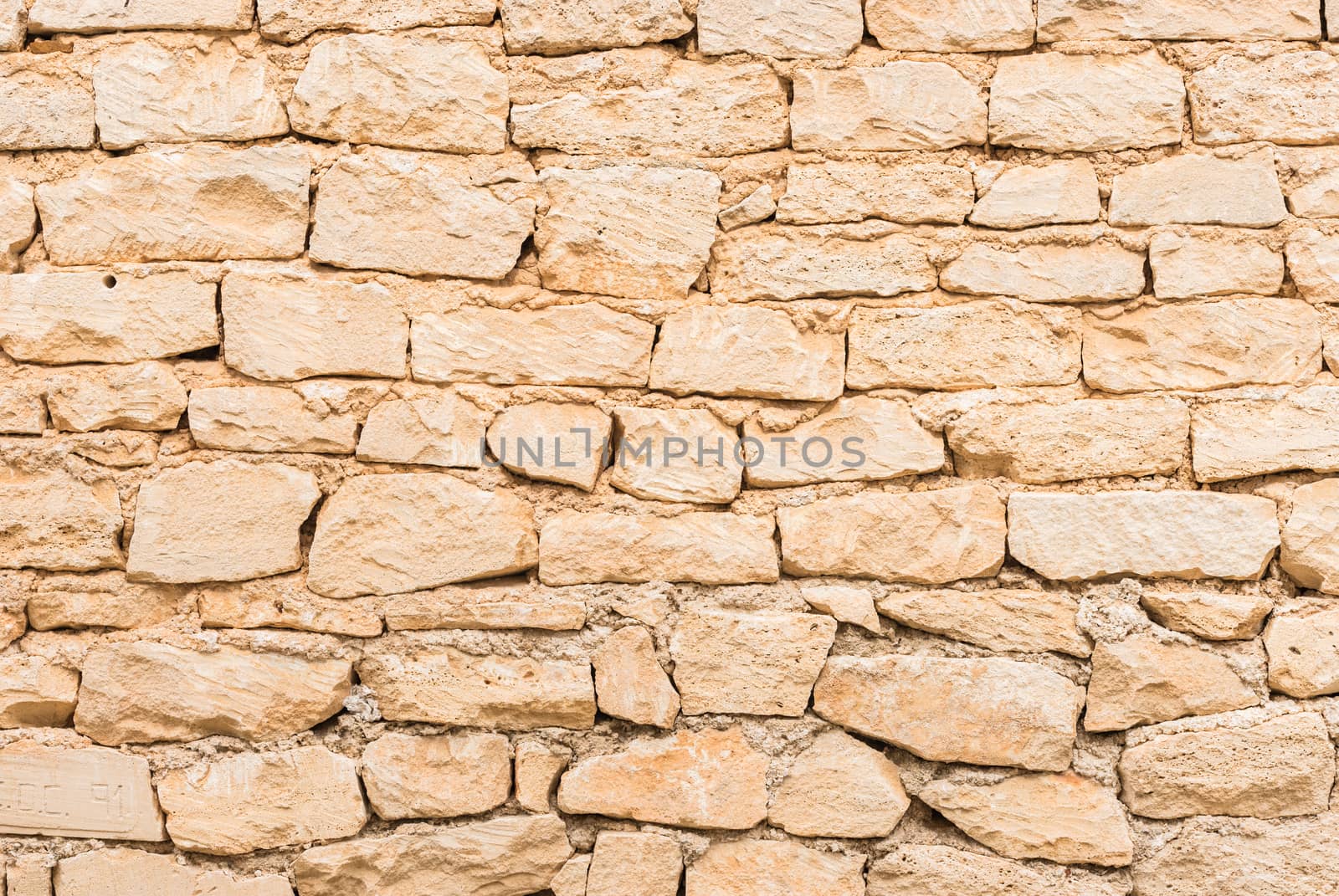 Rustic old beige stone wall texture background structure