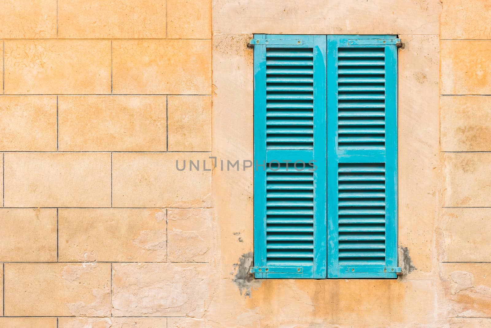 Detail view of wooden window shutters and wall