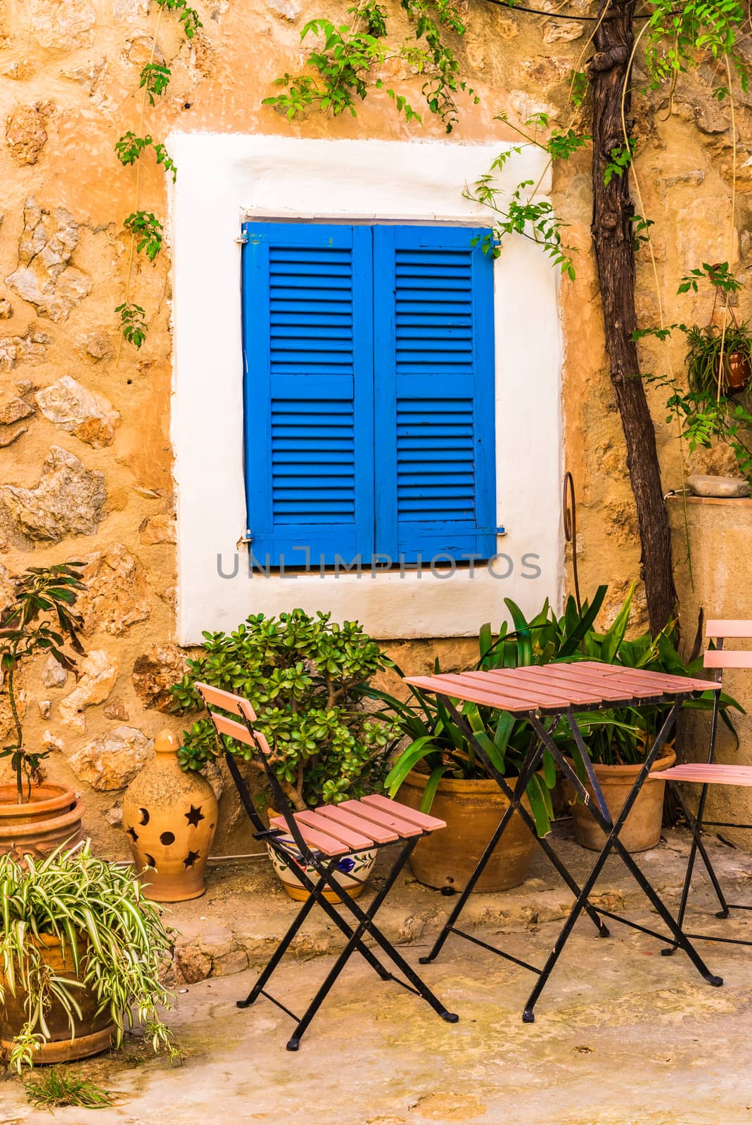 View of idyllic patio of mediterranean house with blue window shutters