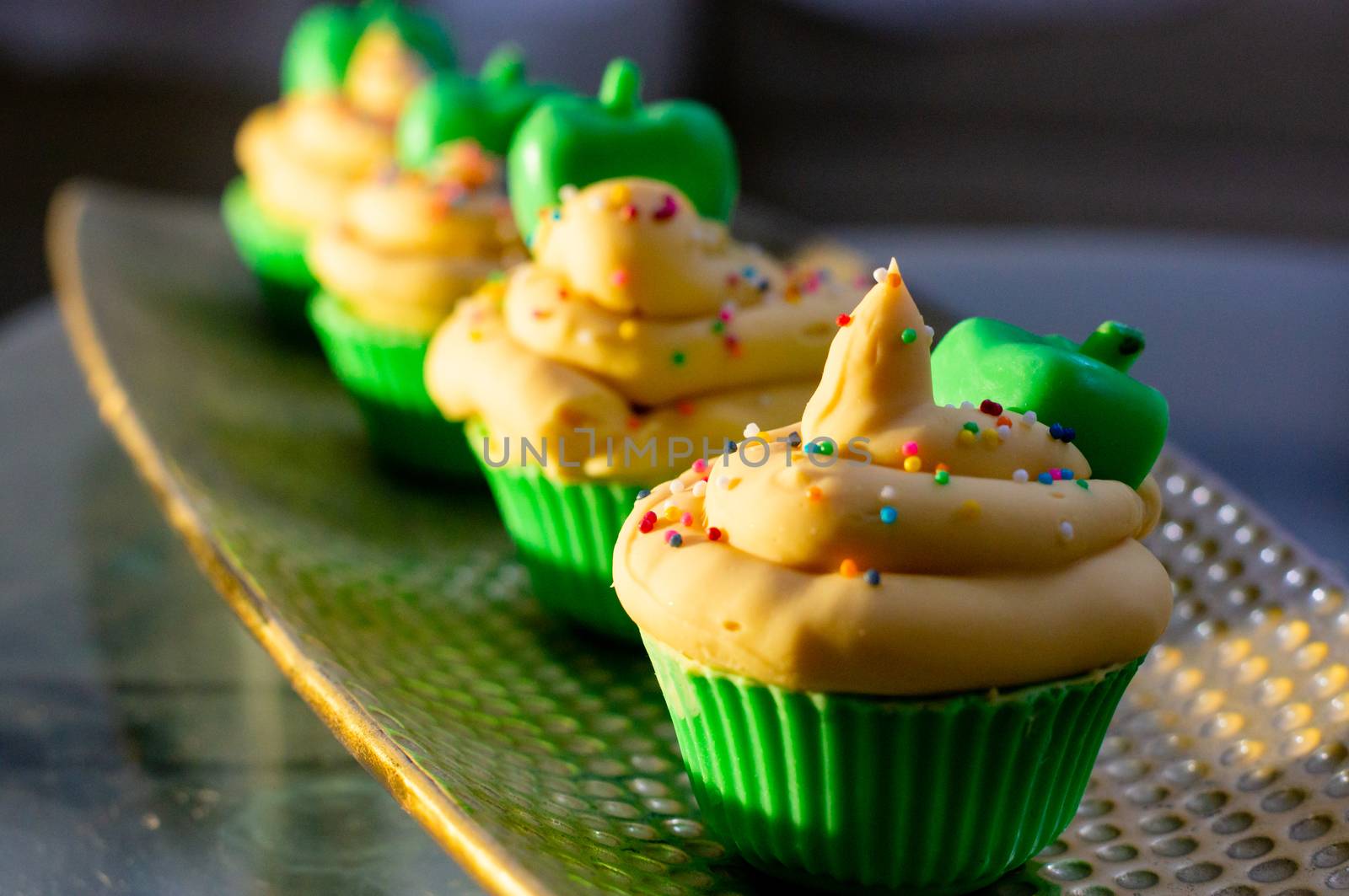 Delicious looking cupcake sot aps with green base and yellow lemon cream colorful sprinkles shot in golden sunrise light. Shows beautiful clean soap as a hobby or a home business for SLS free, paraben free artisanal handmade soaps