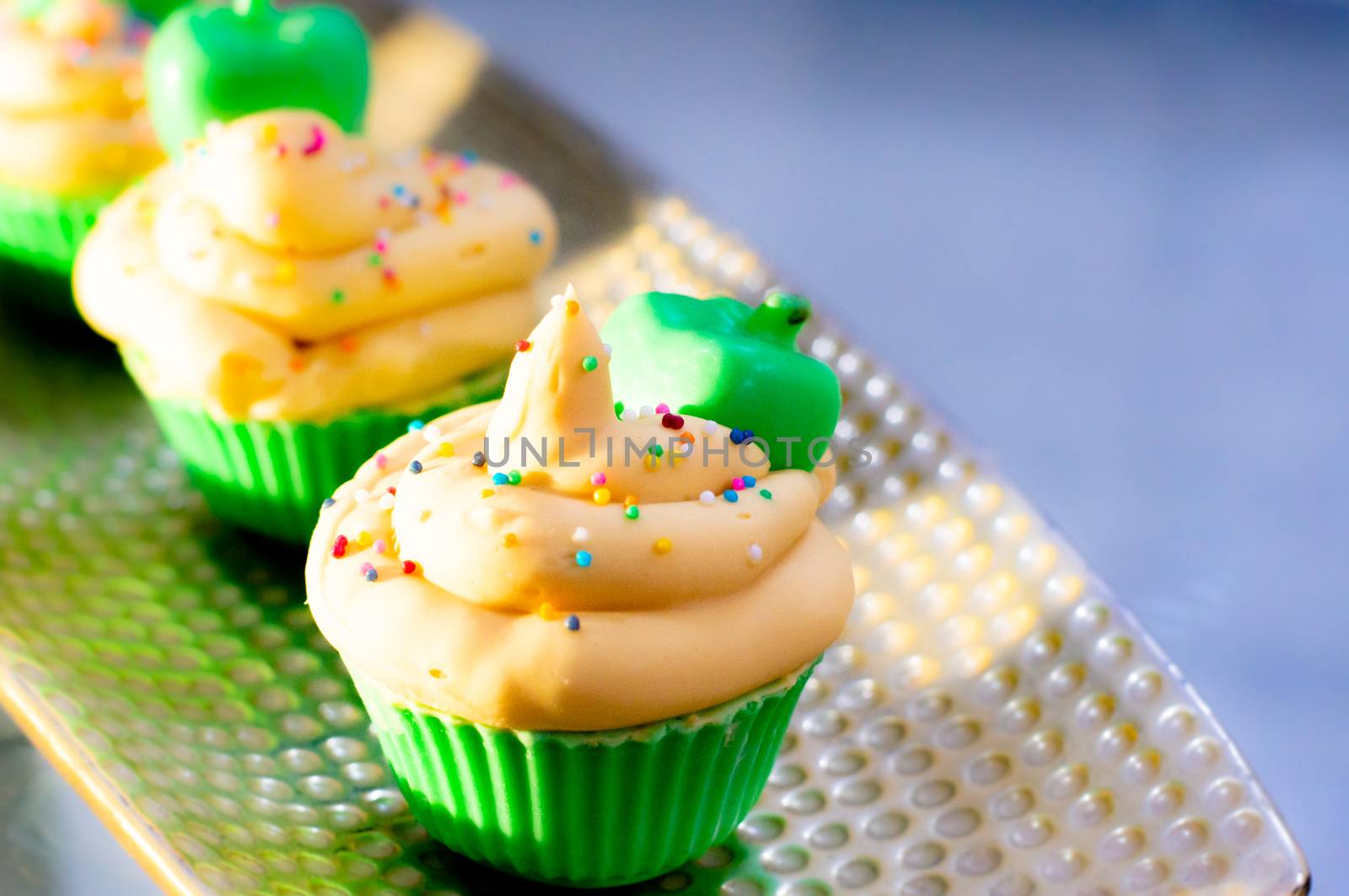 Delicious looking cupcake sot aps with green base and yellow lemon cream colorful sprinkles shot in golden sunrise light. Shows beautiful clean soap as a hobby or a home business for SLS free, paraben free artisanal handmade soaps