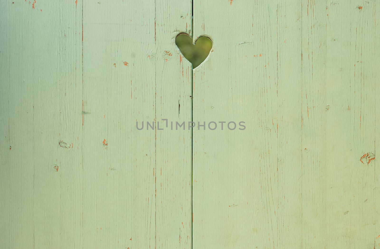 Love heart carved on old green wooden background with copy space