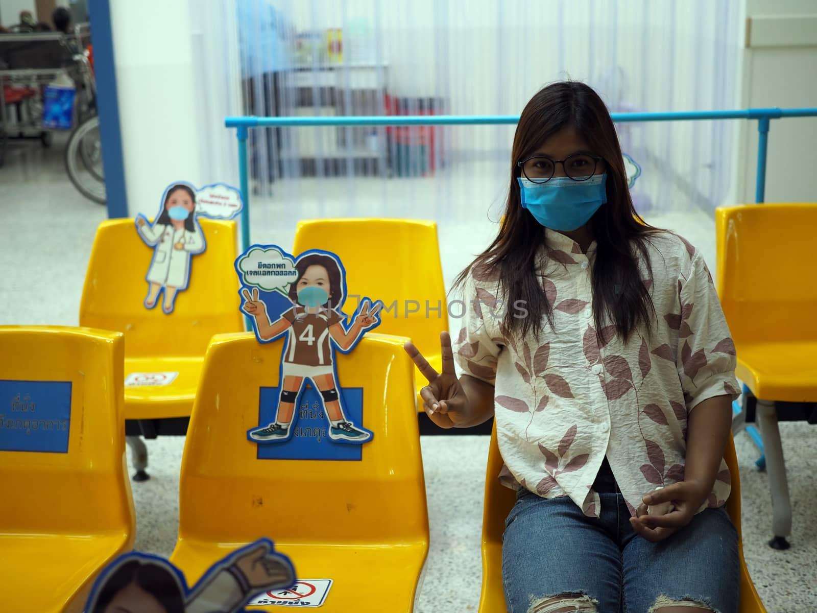 Asian women wear protective masks and sit on chairs to maintain by Unimages2527