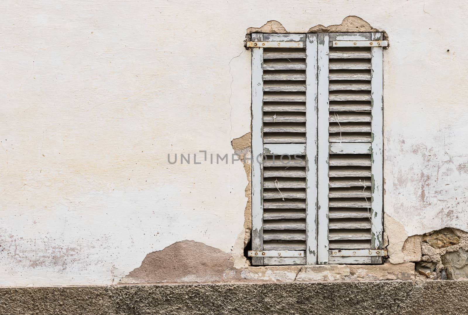 Detail view of vintage wooden window shutters and grunge damaged wall background