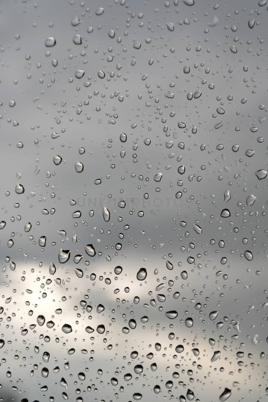 Abstract background, water drops on a window glass, rainy day