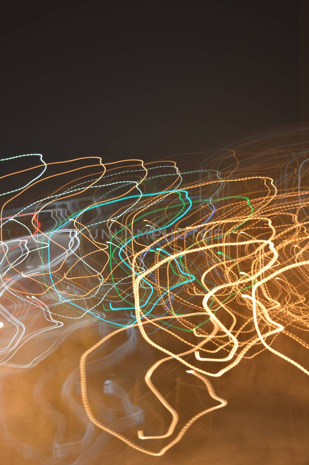 Abstract background, color lights into motion over dark. Shallow dof