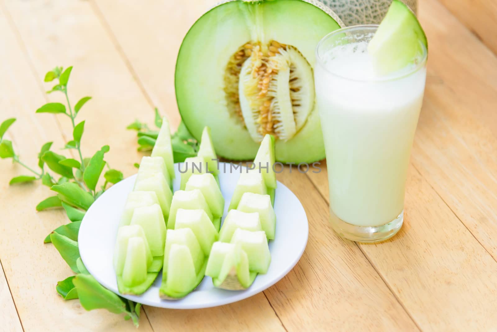 Fresh green melon on wood plate by rukawajung