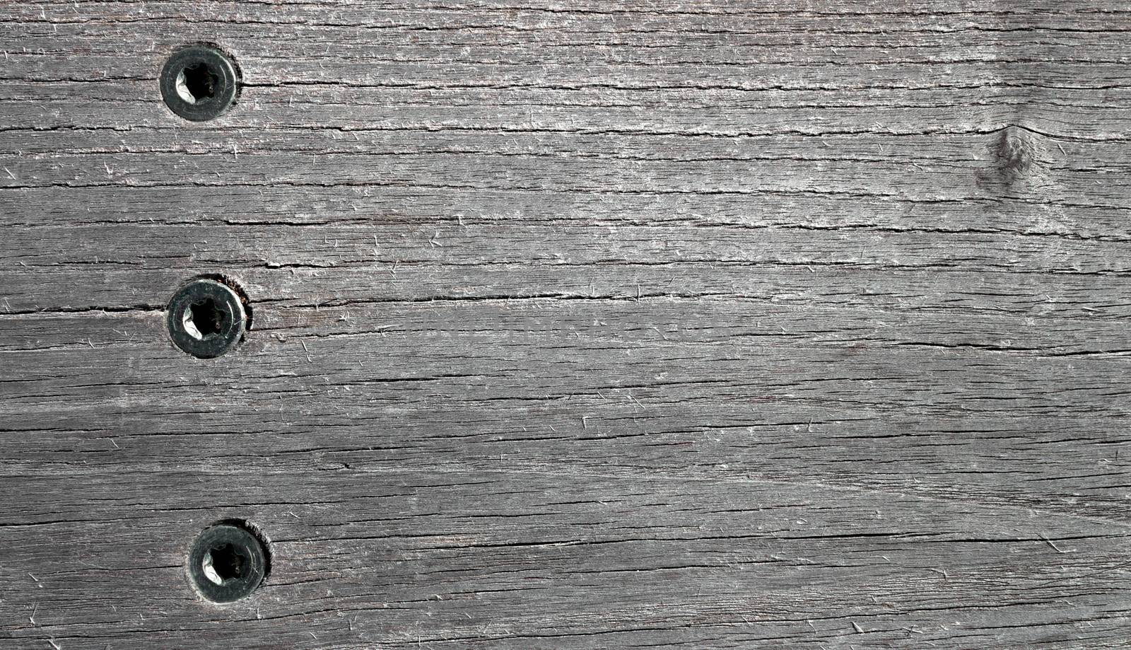 Black and white wooden background with three steel rivets. Elegant texture for many uses.