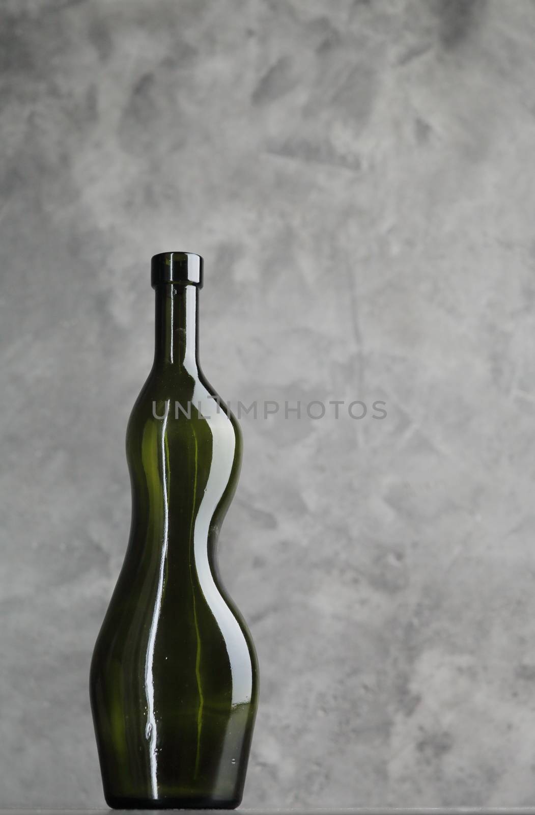 Wine bottle on a concrete background. Free space for inscription. by selinsmo