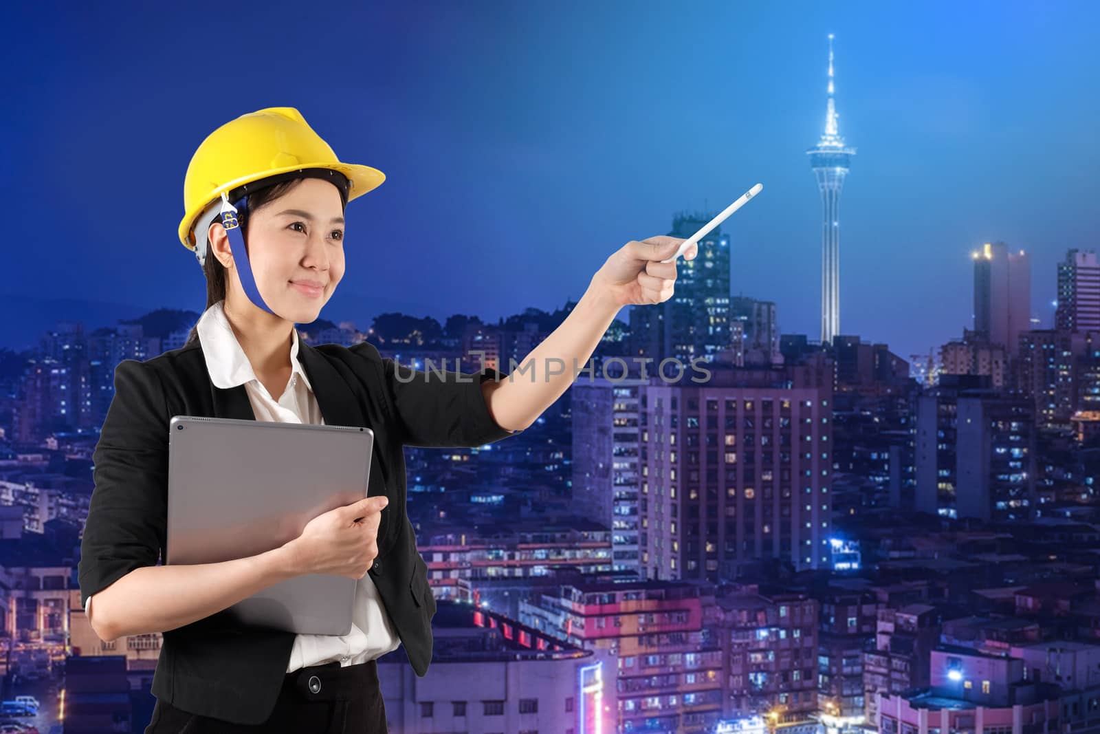 Young woman engineer holding digital tablet wtih smile in night  by Surasak