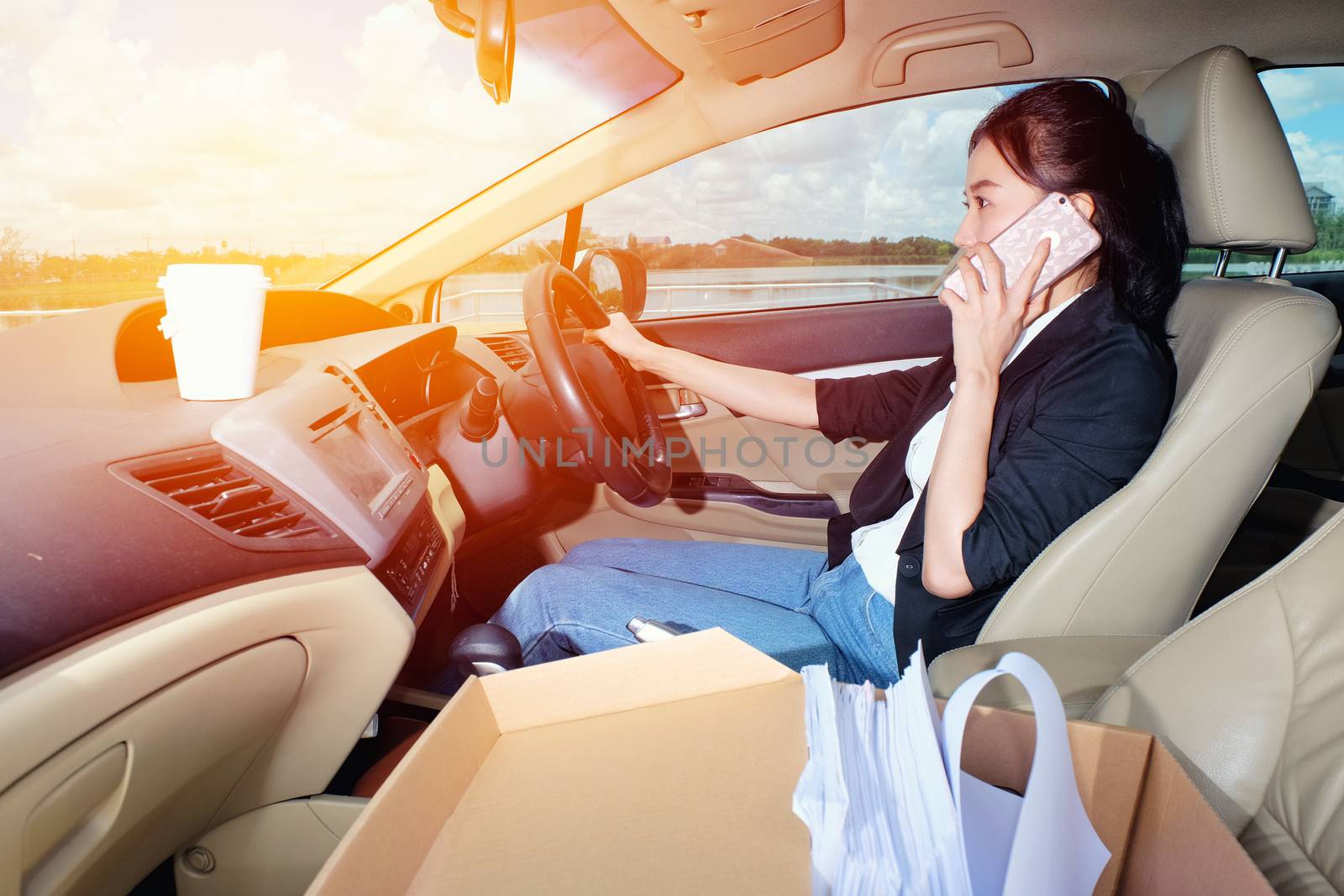 Young woman talking her mobile phone. in the car. by Surasak