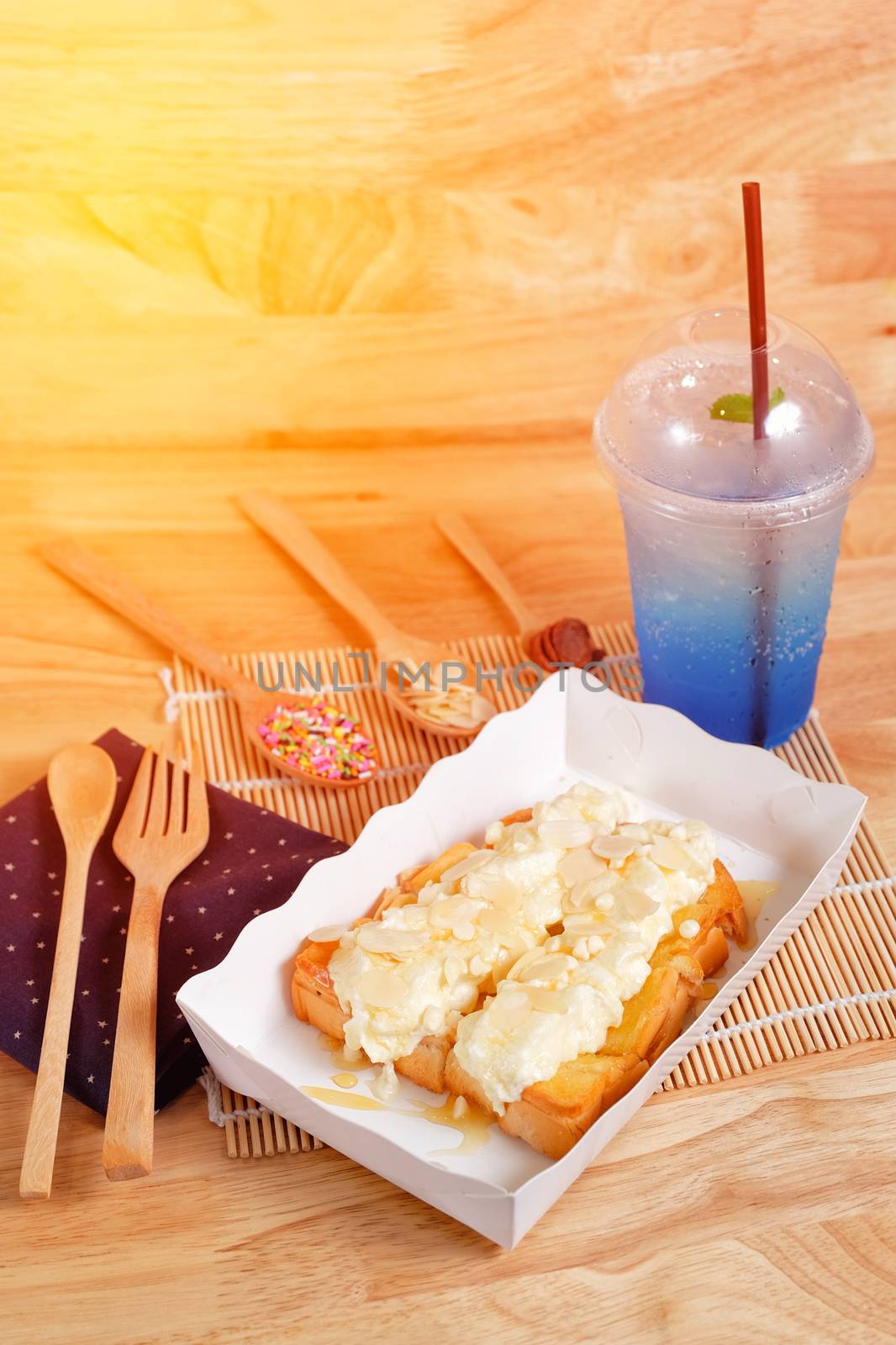 Toast butter with whip cream topping on wood background by Surasak