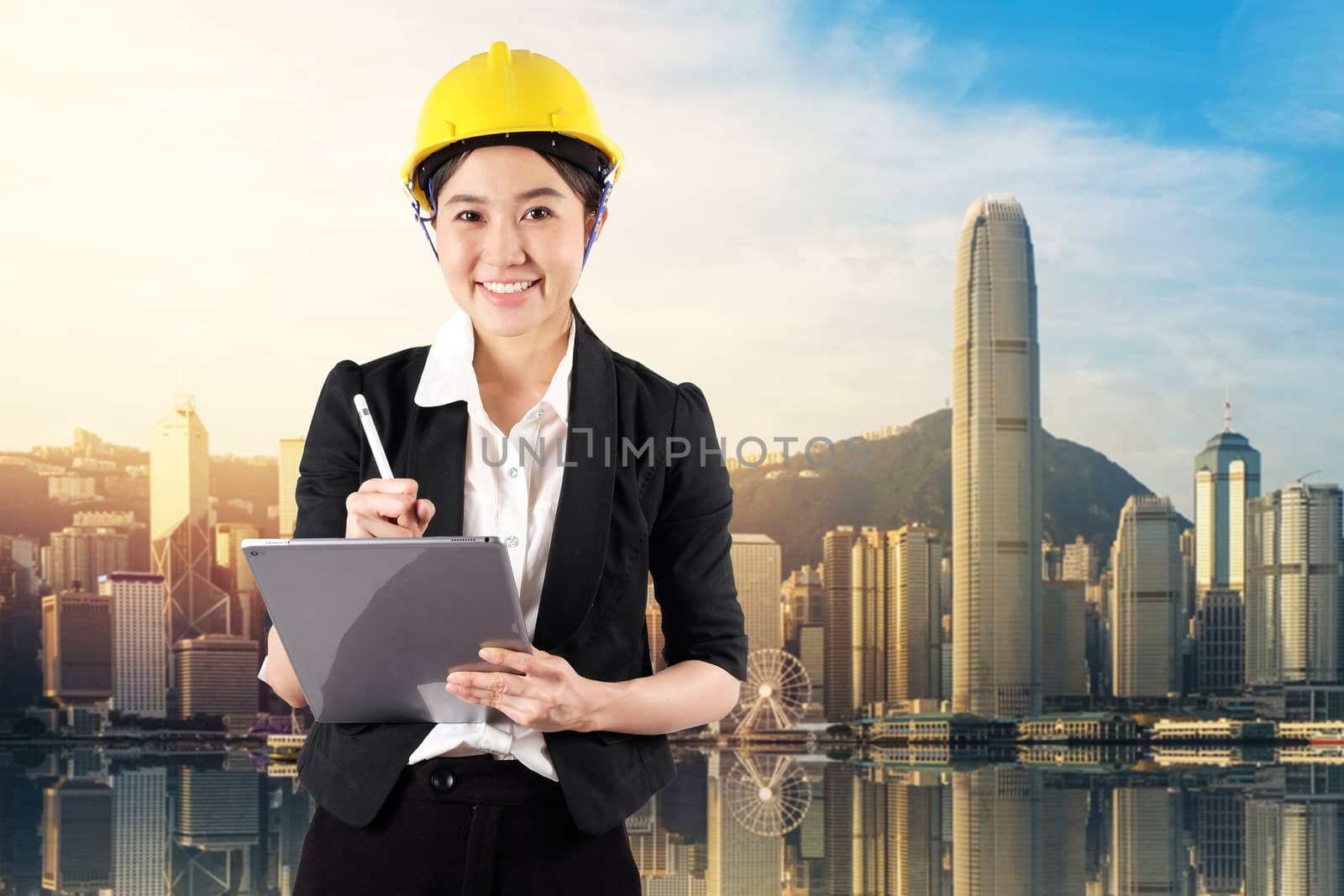 Young woman engineer holding digital tablet wtih smile in daylight cityscape background