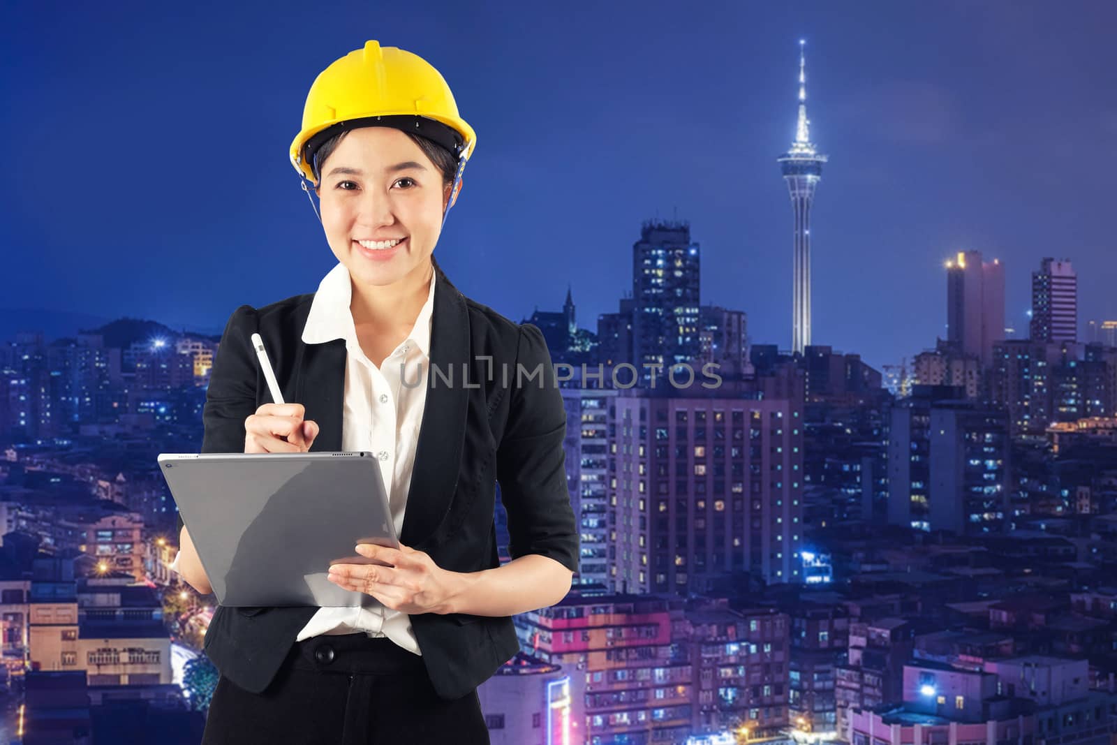 Young woman engineer holding digital tablet wtih smile in night cityscape background