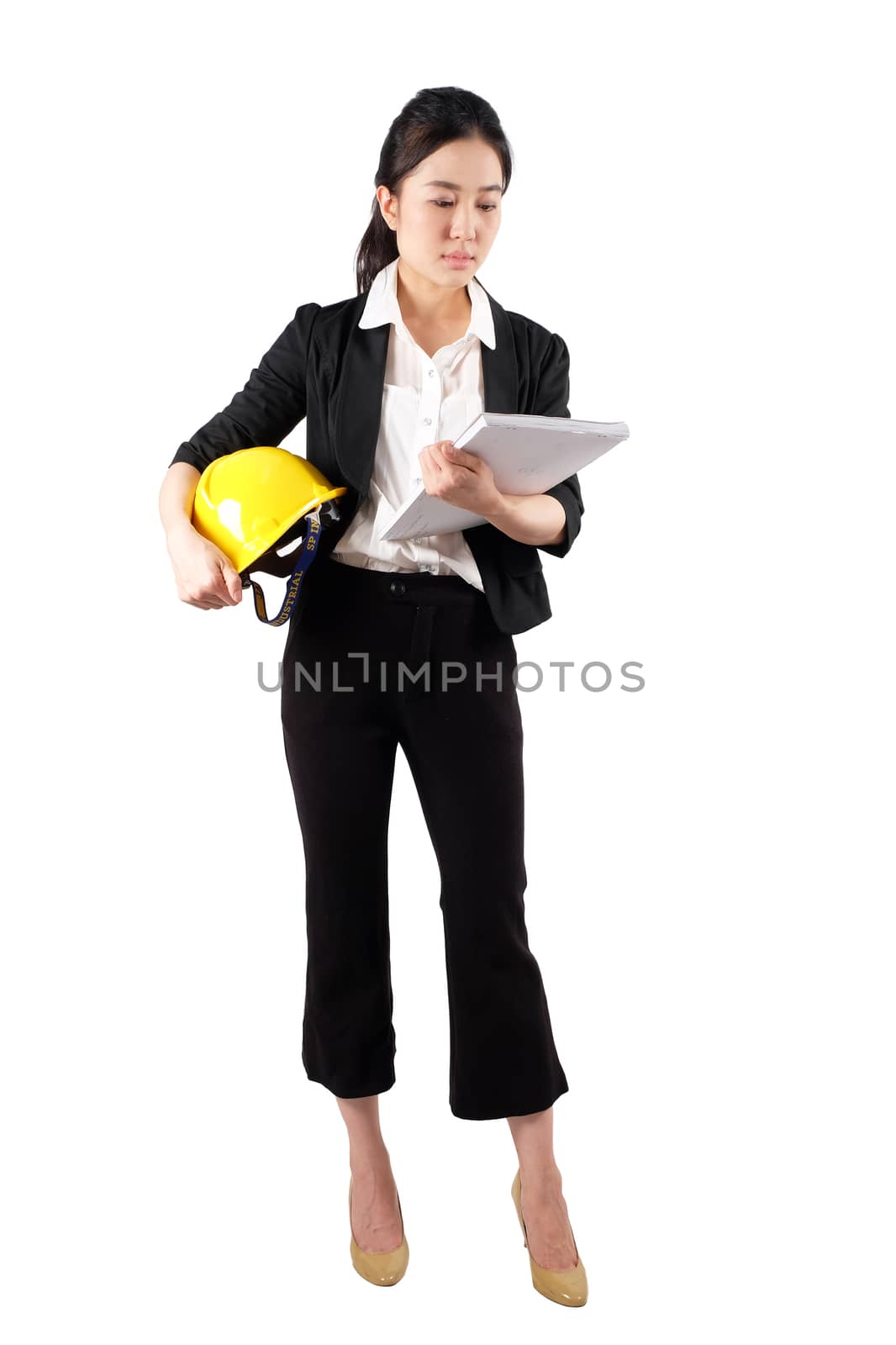 Young woman engineer holding a yellow helmet and reading construction documents on white background 
