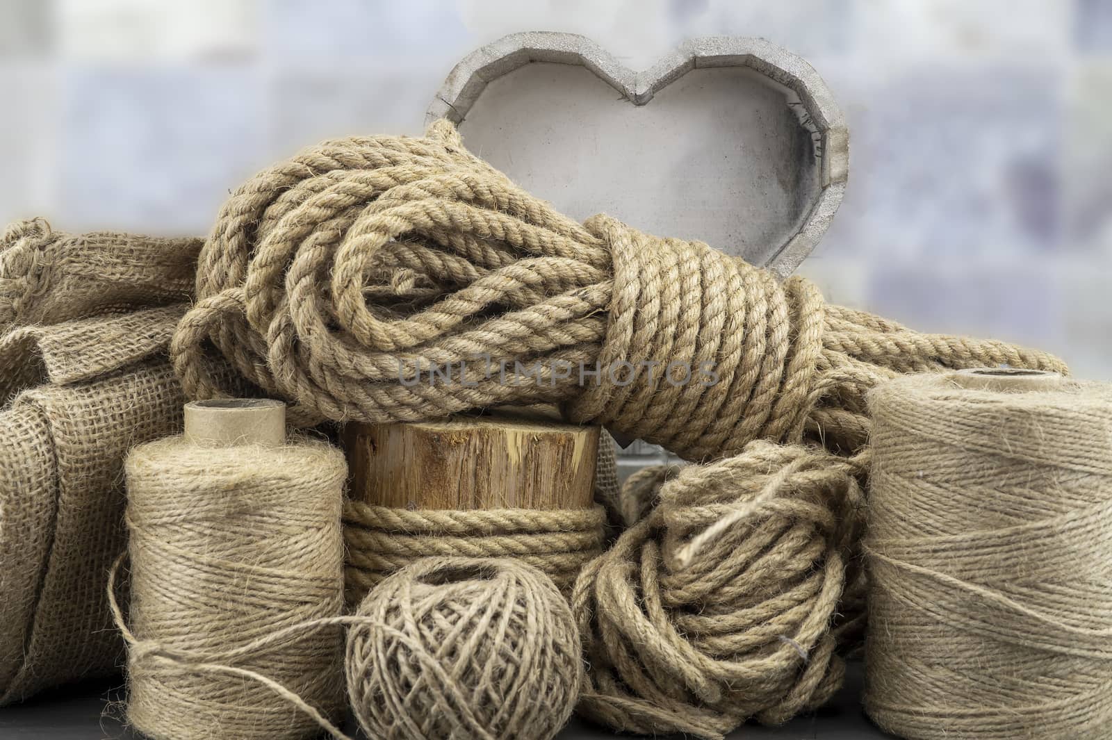 Assorted balls of jute twine and string with skeins of rope in a close up rustic still life