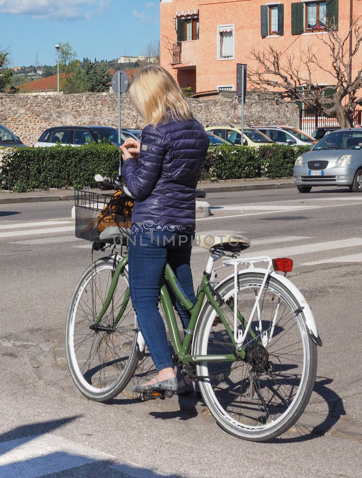 Beatiful woman riding a bike in Verona by claudiodivizia