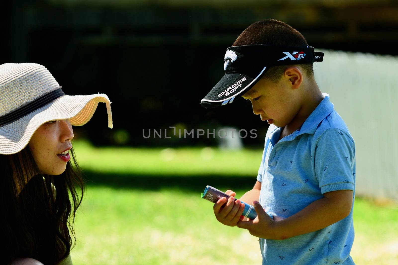 An unidentified young asian woman talking to her little son