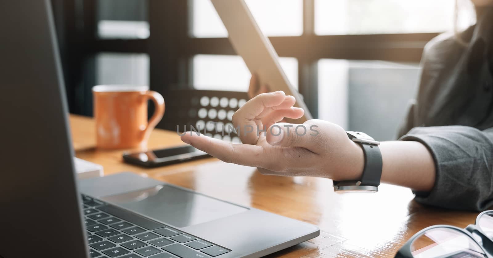 Young woman use tablet computer for business analyze and hand potinting on computer by nateemee