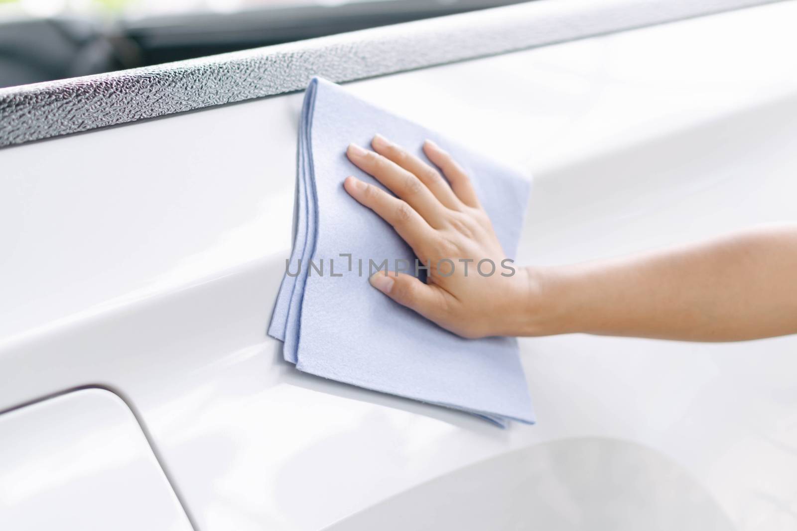 Man cleaning car with microfiber cloth, car detailing (or valeting) concept. Selective focus.