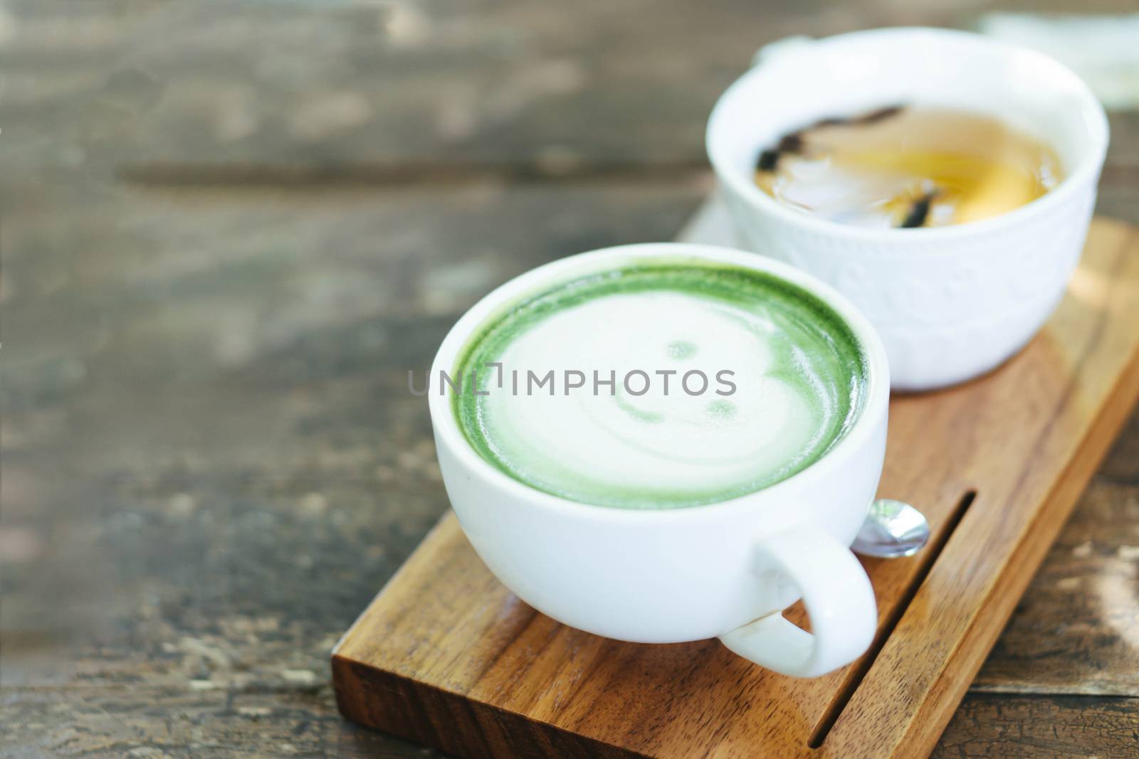 Closeup glass of matcha green tea shape on wood background with vintage color, selective focus