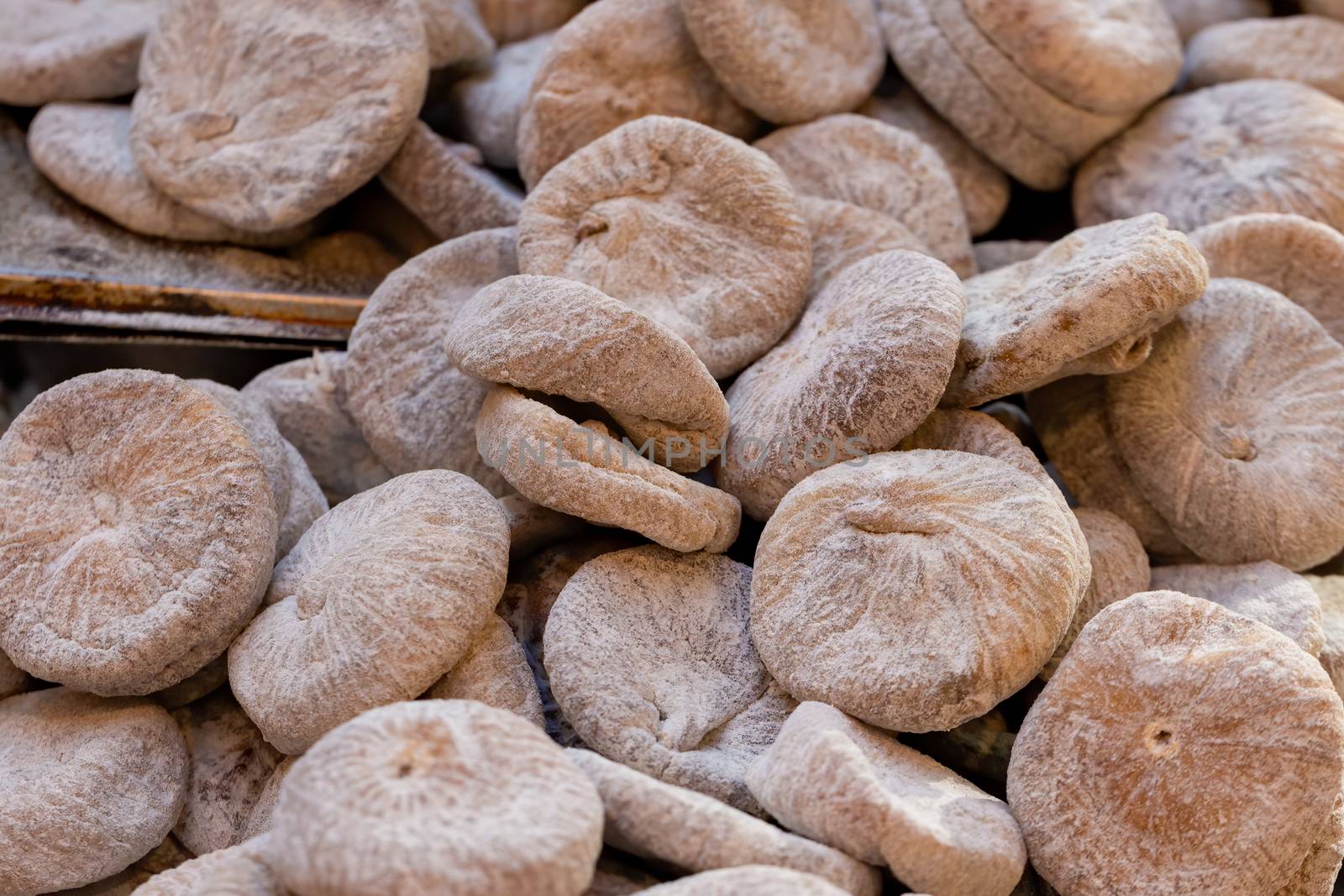 Dried figs, coated in wheat flour, on a market stall by magicbones