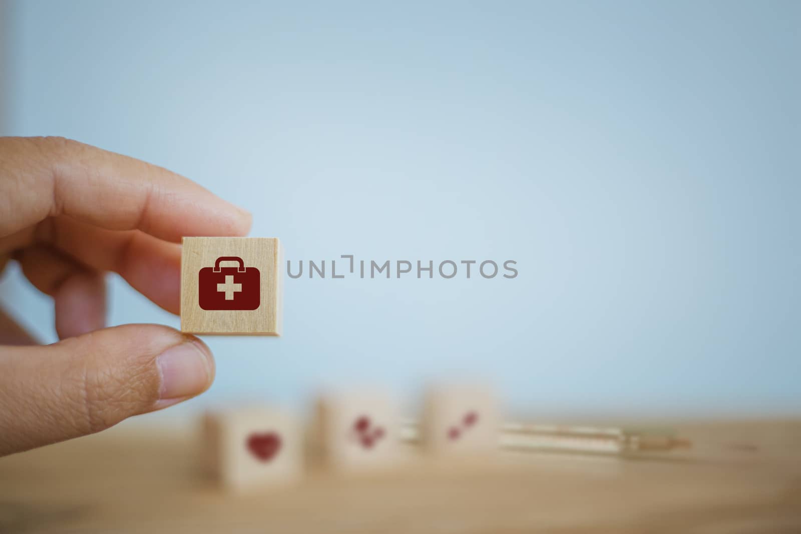 Medical treatment / Operating system / Healthcare concept: Hand chooses wooden cube blocks with icon on table. Depicts responsibility for self-health in nutrition to ensure integrity Without illness. by setila