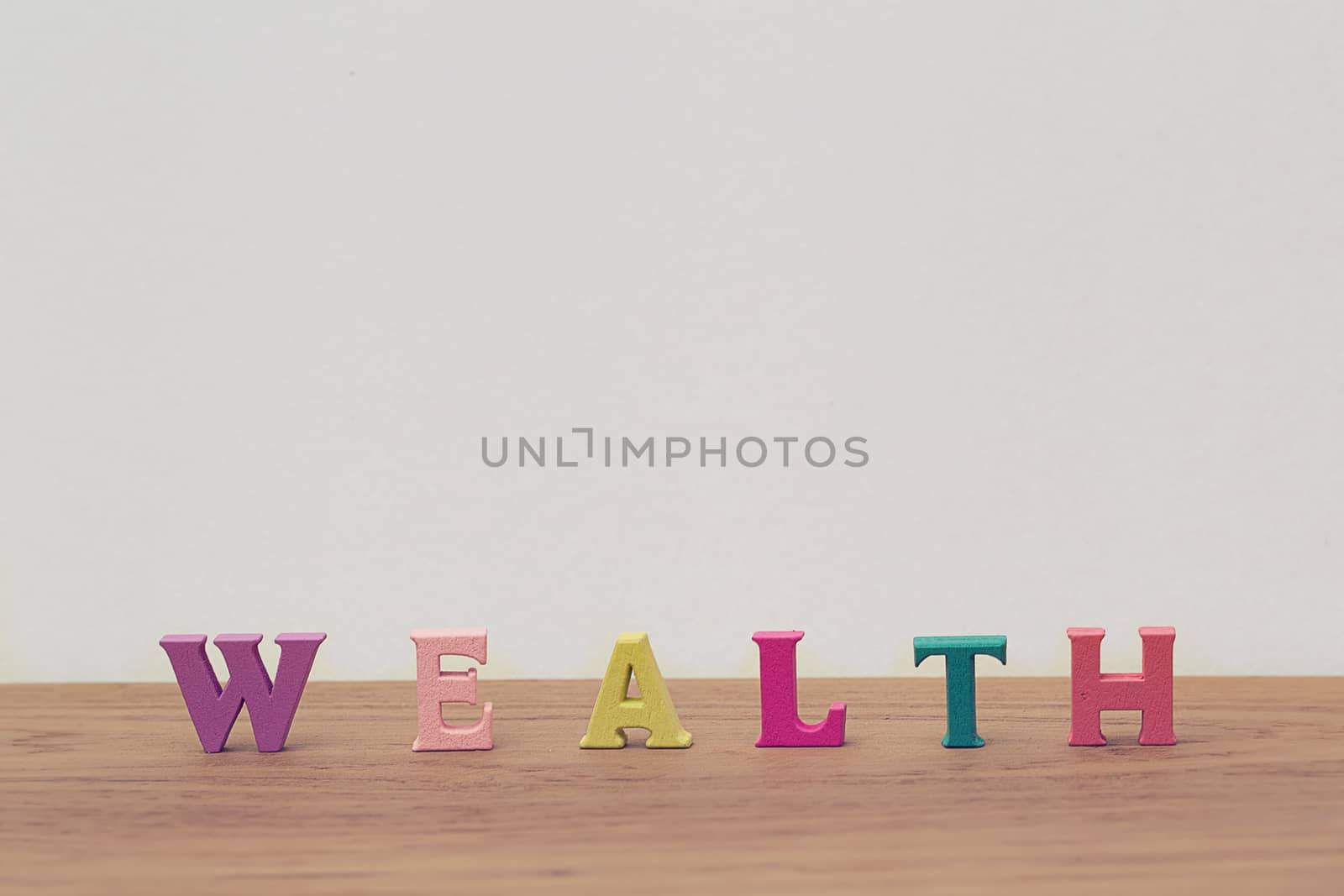 Creative idea of arrange the letters of word "WEALTH" on table. Investment in life insurance and healthcare concept.