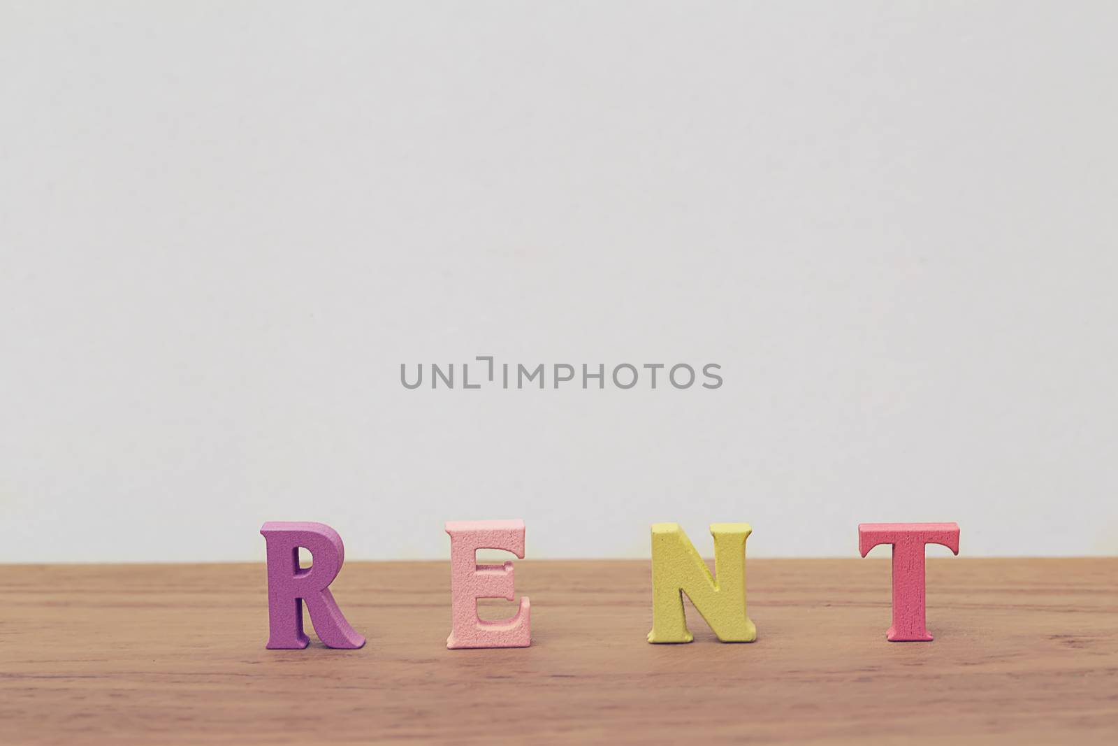 Creative idea of arrange the letters of word "RENT" on table. Buying a right to temporarily own something this right means being able to make full use of rented items.