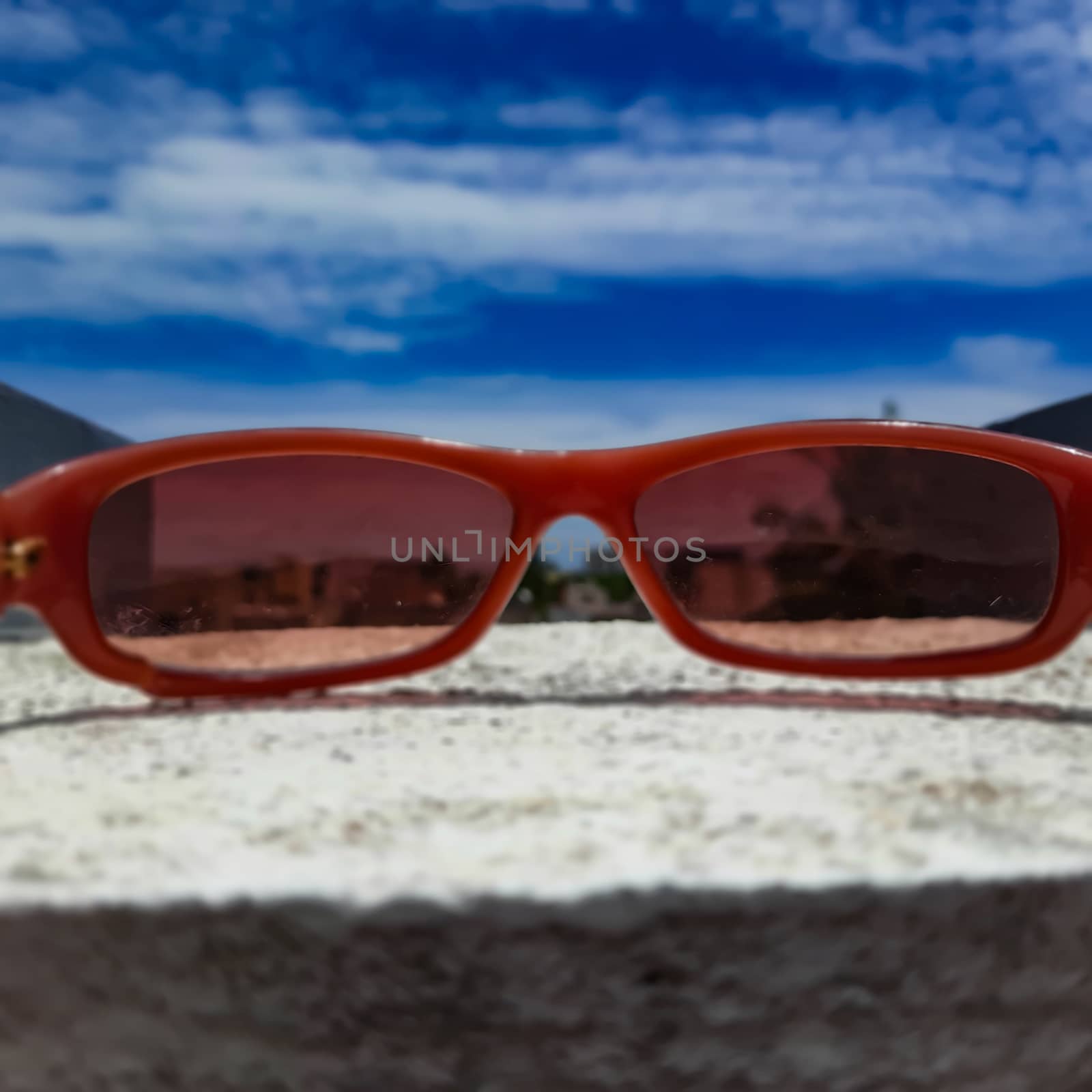 Chennai, India - July 3 2020: Red color glass placed in wall to see beautiful view of the sky from the glass lens