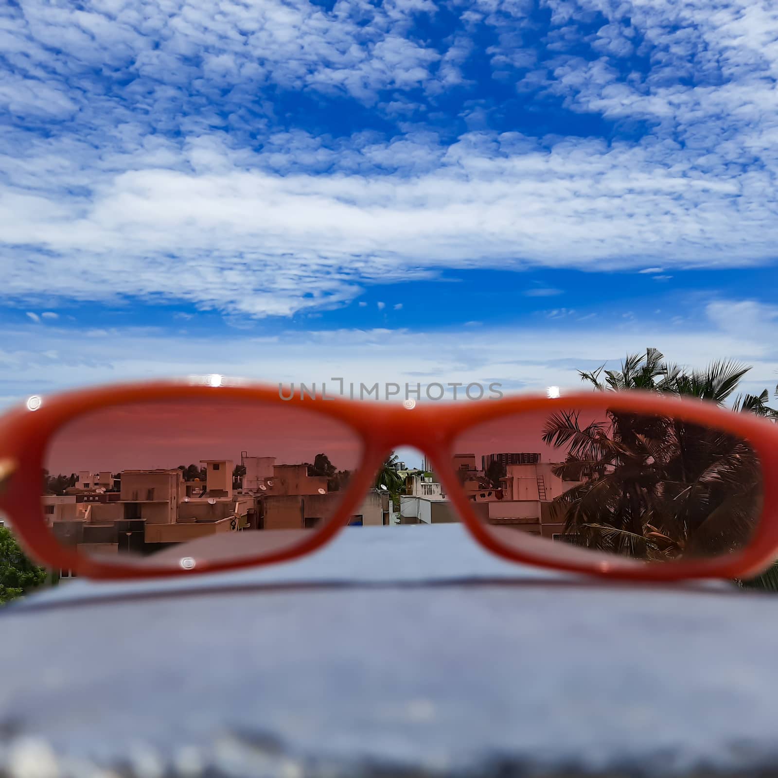 Chennai, India - July 3 2020: Red color glass placed in wall to see beautiful view of the sky from the glass lens