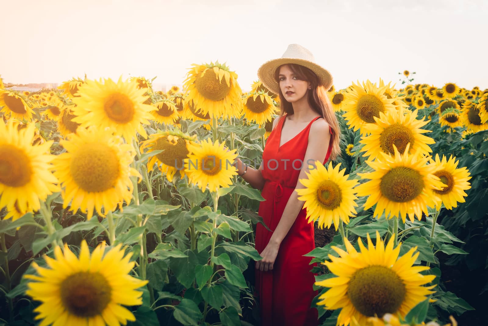 woman with red dress in sunflower field.