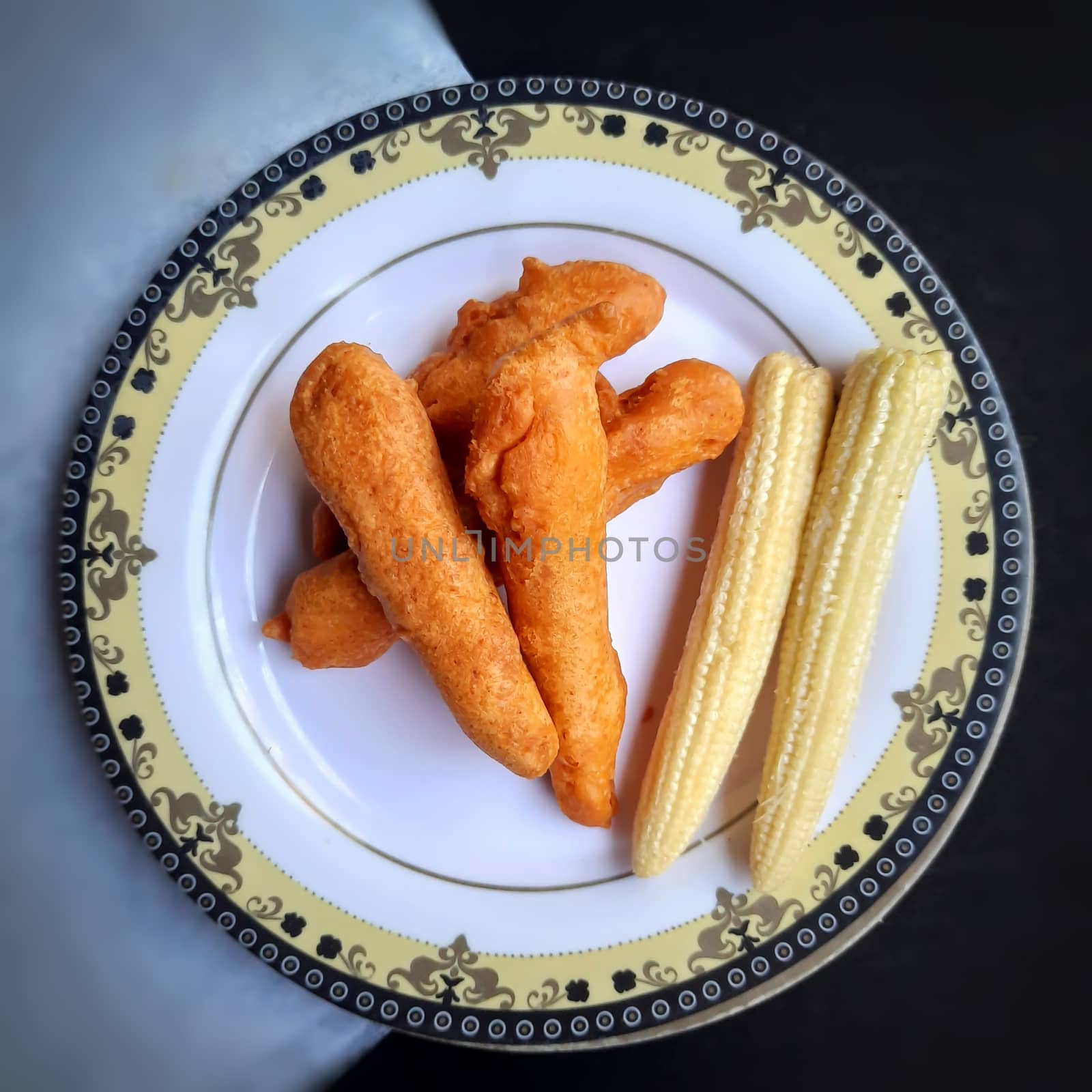 Delicious hot Baby corn baji with fresh baby corn placed in plate with white and black backgrounds and packed with vital antioxidants and has essential fibres