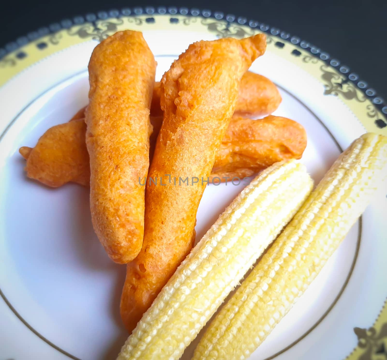 Delicious hot Baby corn baji with fresh baby corn placed in plate with black backgrounds and packed with vital antioxidants and has essential fibres