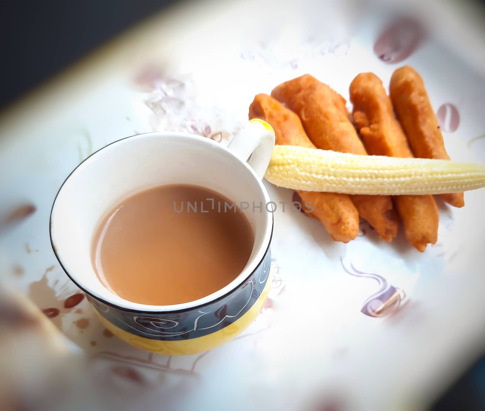 Delicious hot Baby corn baji with fresh baby corn and cup of tea placed in plate with black backgrounds and packed with vital antioxidants and has essential fibres